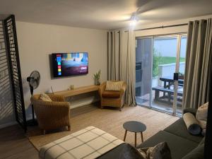 a living room with a couch and a tv at Durbanville Self Catering Apartments in Durbanville