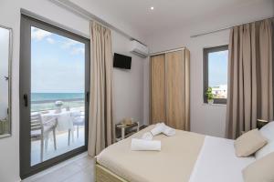a hotel room with a bed and a view of the ocean at Nefeli Rooms in Agia Marina Nea Kydonias