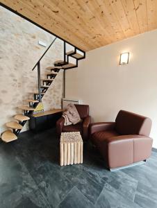 a living room with a couch and a staircase at Le Box Circuit Magny-Cours in Saint-Parize-le-Châtel +2 photos