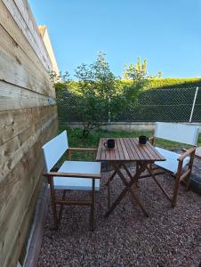 two chairs and a picnic table on a patio at Le Box Circuit Magny-Cours in Saint-Parize-le-Châtel