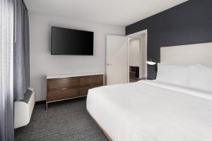 a hotel room with a bed and a flat screen tv at Courtyard Mobile in Mobile