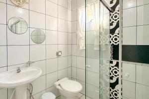 a white bathroom with a toilet and a sink at Residencial Zirke in Florianópolis +50 photos