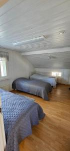 a bedroom with three beds in a room at Arctic House Kemi 7 GUEST, outdoor tentsauna Experience in Kemi