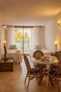a living room with a table and chairs and a bedroom at Coral Confort APTS San Andres in San Andrés
