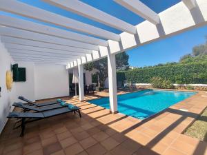 a villa with a swimming pool and a white pergola at VILLA SAVINA in Cala en Blanes