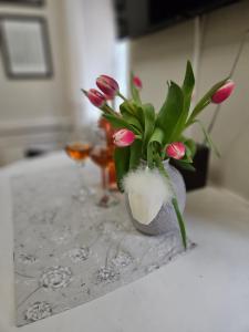 a vase filled with pink flowers on a table at Apartmán Marína in Banská Štiavnica +22 photos