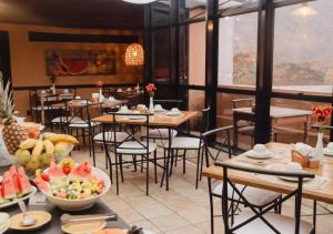 a restaurant with tables and chairs with a bowl of fruit at Kastel Itaipava in Itaipava +20 photos