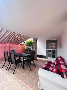 a patio with a table and chairs and a couch at Alex Vip Apartman in Hajdúszoboszló