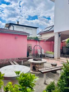 a patio with a fire pit and benches and a building at Alex Vip Apartman in Hajdúszoboszló