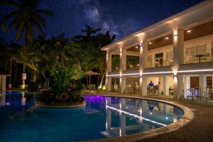 a resort with a swimming pool at night at Honduras Shores Plantations in Tela