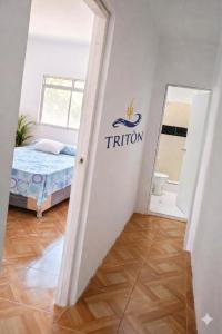 a room with a bed and a sign on the wall at Casa de Playa Triton in Máncora +1 photo