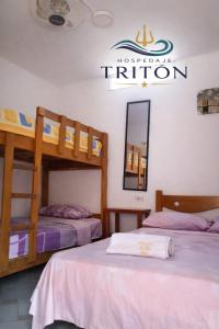 a room with two bunk beds and a sign on the wall at Casa de Playa Triton in Máncora