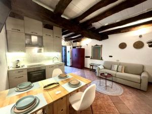 a kitchen and living room with a table and a couch at Casa Zita Cozy • AC near Lake Como by Gottschalk in Olgiasca