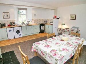 a kitchen with a table and a kitchen with a table and chairs at The Coach House in Girvan