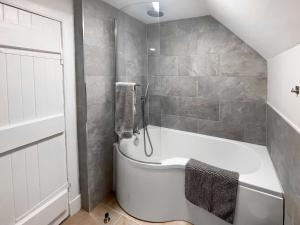 a bathroom with a white tub and a shower at The Coach House in Girvan