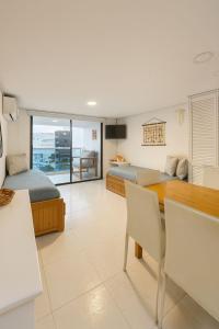 a room with two beds and a table and chairs at Coral Confort APTS San Andres in San Andrés