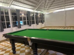 a green pool table in a room with windows at Vista villa in Pushkar