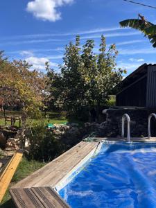a swimming pool in a yard with a wooden deck at l'atelier by Emma in Bommes