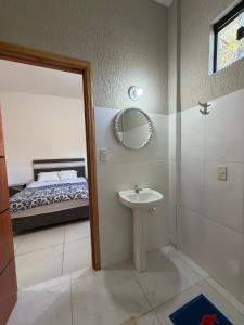 a bathroom with a sink and a mirror and a bed at JG&A Home in Itauguá +105 photos