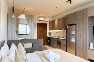 a kitchen and a living room with a bed and a couch at Swiss Lodge, Labone in Accra