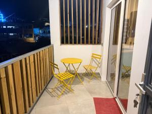 a balcony with two chairs and a table at Le manga in Chiconi