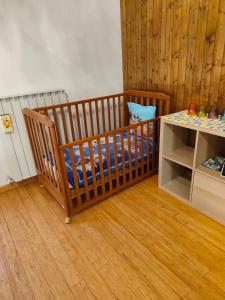 a baby crib in a room with a table at "IL Tulipano" appartamento, o doppia camera quadrupla, con bagno in Sestri Levante