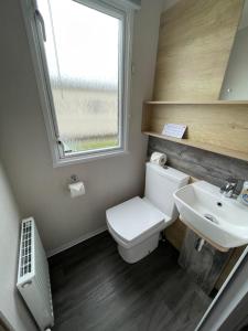 a bathroom with a toilet and a sink and a window at Static in Peak District Ashbourne Heights Derbyshire Play Park Indoor Pool in Tissington +12 photos