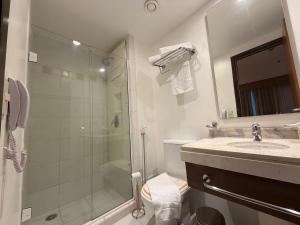 a bathroom with a glass shower and a sink at Hotel Wynd Ibirapuera 512A in São Paulo
