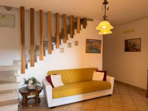 a living room with a yellow couch and stairs at Sperlonga Paradise Central House in Sperlonga