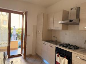 a kitchen with a stove top oven next to a window at Sperlonga Paradise Central House in Sperlonga +8 photos