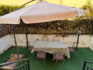 a table and chairs under a large umbrella at Sperlonga Paradise Central House in Sperlonga