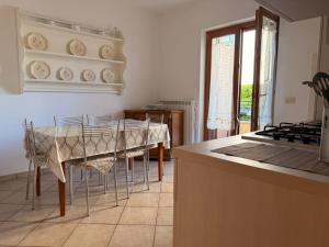 a kitchen with a table with chairs and a stove at Sperlonga Paradise Central House in Sperlonga
