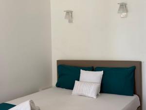 a bed with blue and white pillows in a room at Residence Anse des sables in Marigot