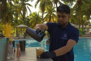 a man is making a drink by a pool at Honduras Shores Plantations in Tela +64 photos