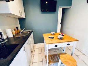 a small kitchen with a wooden table and a sink at Petite maison Cosy Le gaucher in Muret +2 photos