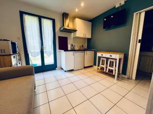 a kitchen with white appliances and green walls at Petite maison Cosy Le gaucher in Muret