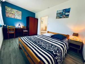 a bedroom with a bed and a desk and a chair at Petite maison Cosy Le gaucher in Muret