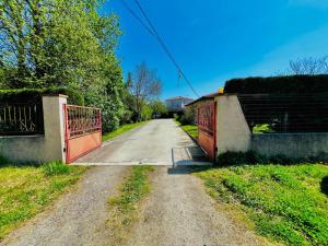 an empty road with a red gate on a bridge at Petite maison Cosy Le gaucher in Muret