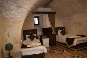 a bedroom with two beds and a tv in it at JOSELİN HOTEL in Urfa +84 photos
