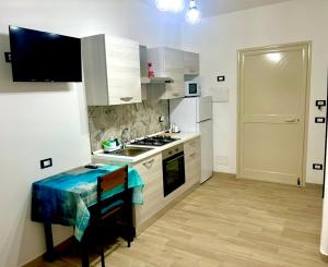 a kitchen with white cabinets and a stove top oven at Casetta Marisù in Partinico