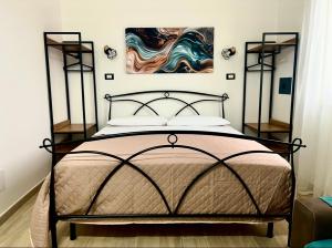 a bedroom with a bed and a painting on the wall at Casetta Marisù in Partinico