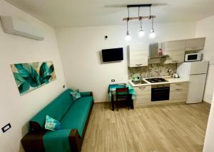 a living room with a green couch in a kitchen at Casetta Marisù in Partinico