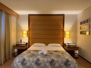 a bedroom with a large bed and a wooden headboard at Hotel Wynd Ibirapuera 512A in São Paulo +18 photos