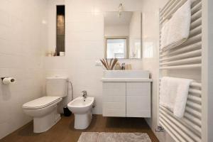 a white bathroom with a toilet and a sink at Acqua & Luce in Meina +7 photos