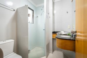 a bathroom with a shower and a toilet and a sink at Brivali Hotel e Eventos in Caçador +64 photos