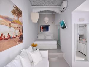 a white bedroom with a bed and a couch at Chiara Mykonos in Mikonos