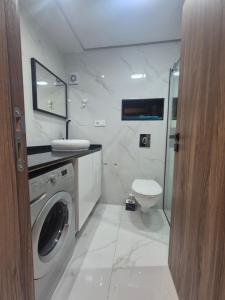 a bathroom with a washing machine and a toilet at Appartement rif roayal in Al Hoceïma +7 photos
