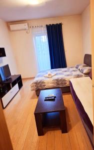 a room with two beds and a coffee table at Clarissa apartment City Kvart in Podgorica