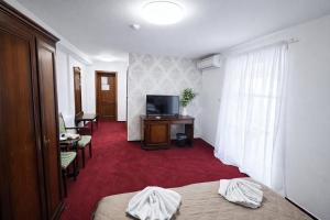 a hotel room with two beds and a flat screen tv at Hotel Sebastian u Hoffera in Modra
