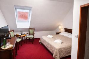 a bedroom with a bed and a table and chairs at Hotel Sebastian u Hoffera in Modra +20 photos